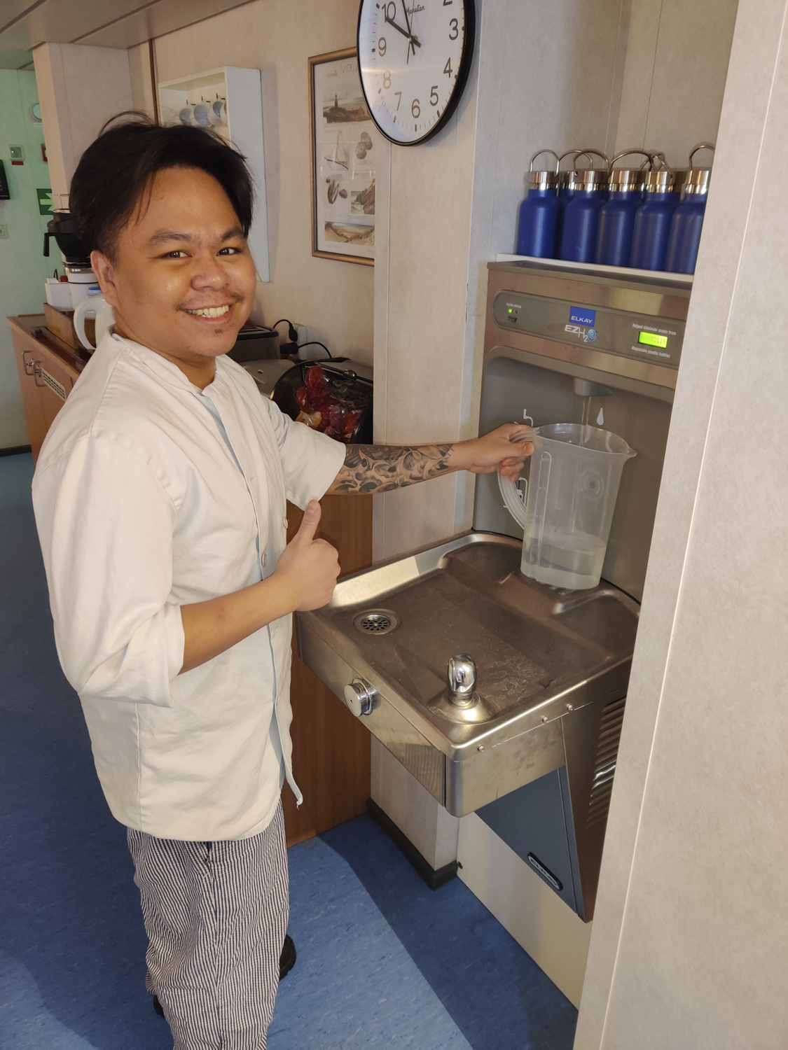 The cook fills a water jug for use during lunch.